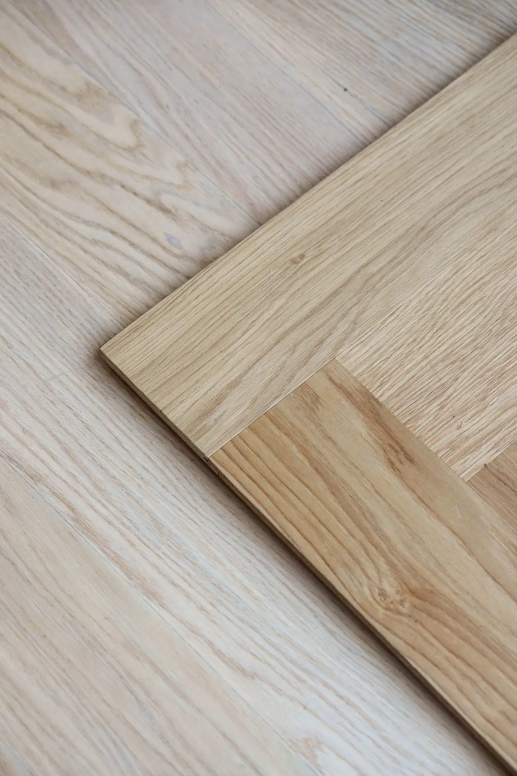 Close-up van een visgraatvloer van licht eikenhout.