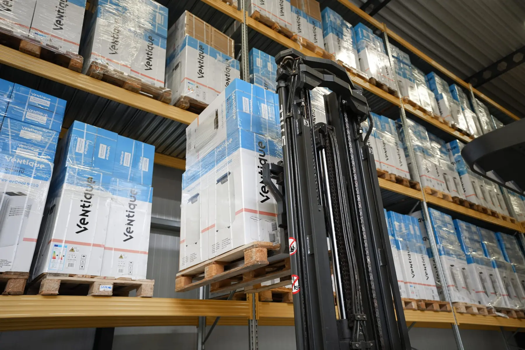 Een reachtruck tussen stellingen vol verpakte producten.
