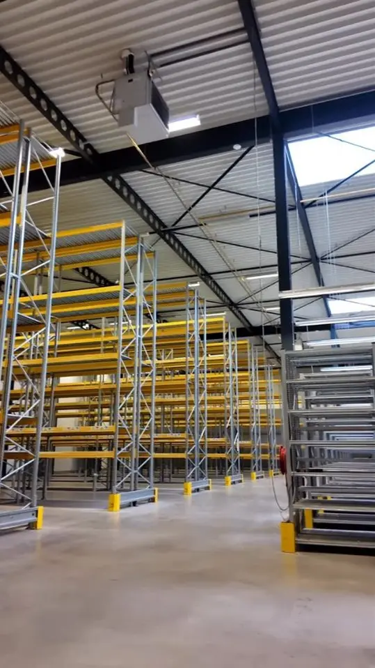Reelcover van Innostock: een lege stelling in de magazijnhal.